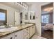 Bathroom featuring a double sink vanity with granite countertop and a large mirror at 822 Shadowstone Dr, Highlands Ranch, CO 80129