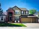 Charming two-story home with brick accents, mature trees, and a well-manicured lawn at 822 Shadowstone Dr, Highlands Ranch, CO 80129