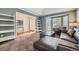 Open living room with blue walls, carpet, and a bay window that provides natural light at 822 Shadowstone Dr, Highlands Ranch, CO 80129