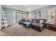 Comfortable living room with a large bay window, a leather sectional, and modern decor at 822 Shadowstone Dr, Highlands Ranch, CO 80129