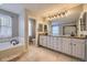 Bright main bathroom with dual vanity sinks, a soaker tub, and a separate shower, creating a functional space at 822 Shadowstone Dr, Highlands Ranch, CO 80129