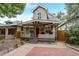 Quaint home exterior with a covered porch, red brick walkway, and well-maintained landscaping at 3440 W 33Rd Ave, Denver, CO 80211