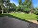 Expansive backyard with lush lawn, mature trees, and a retaining wall at 7290 S Cook Cir, Centennial, CO 80122