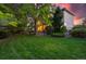 View of the back exterior of a well-maintained home with lush green lawn and mature trees at 5350 S Marshall St, Littleton, CO 80123