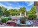 Picturesque backyard featuring a modern fountain, stone accents, and a wrought iron fence, blending nature with design at 5350 S Marshall St, Littleton, CO 80123
