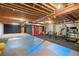 Spacious basement with workout area and exposed beams provides ample room for activities at 5350 S Marshall St, Littleton, CO 80123