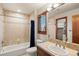 Bright bathroom features a bathtub with shower and a vanity with tan tile countertop at 5350 S Marshall St, Littleton, CO 80123