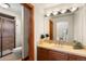 Bathroom featuring tan tiles, a glass shower, and a vanity with a neutral countertop at 5350 S Marshall St, Littleton, CO 80123
