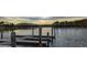 Water view of a dock and posts on a calm lake with trees on the far shoreline at 5350 S Marshall St, Littleton, CO 80123