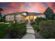 Beautifully landscaped home with a tiled roof, elegant entrance, and illuminated exterior for evening appeal at 5350 S Marshall St, Littleton, CO 80123
