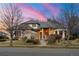 Charming single-Gathering home with brick exterior, mature trees, and manicured front yard, set against a vibrant sunset at 5350 S Marshall St, Littleton, CO 80123