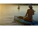 Enjoy a peaceful paddle boarding adventure on the serene lake during a golden sunset, embracing a healthy lifestyle at 5350 S Marshall St, Littleton, CO 80123