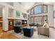 Bright living room featuring a vaulted ceiling, large windows, fireplace, and built-in shelving at 5350 S Marshall St, Littleton, CO 80123