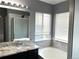 Bright bathroom with marble countertop, garden tub, and glass shower at 5988 W Crestline Ave, Littleton, CO 80123