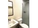Bathroom featuring a shower with glass door, sink and mirror at 5988 W Crestline Ave, Littleton, CO 80123
