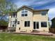 Exterior view of the backyard with grass, patio and yellow vinyl siding at 5988 W Crestline Ave, Littleton, CO 80123