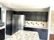 Modern kitchen boasting dark cabinetry, stainless steel appliances, and granite countertops at 5988 W Crestline Ave, Littleton, CO 80123