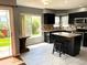 Bright kitchen with an island, black cabinetry, and views of the backyard through a large window at 5988 W Crestline Ave, Littleton, CO 80123