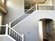 View of staircase with black and white banisters and a stone accent wall at 5988 W Crestline Ave, Littleton, CO 80123