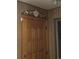 Close up on paneled wood door with flower accent in hallway with wood paneled walls at 7795 Raritan St, Denver, CO 80221