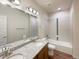 A full bathroom showcasing a granite countertop, double sinks, and a tiled shower-tub combo at 120 Sabin Way, Lochbuie, CO 80603