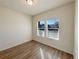 Bedroom with wood floors and bright natural light from the two large windows at 120 Sabin Way, Lochbuie, CO 80603