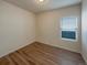 A bedroom with wood-look floors and a window offering natural light at 120 Sabin Way, Lochbuie, CO 80603