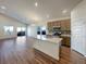 An open-concept kitchen with granite countertops, stainless appliances, and an adjacent living area at 120 Sabin Way, Lochbuie, CO 80603