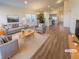 Bright, open-concept living area featuring wood floors, large windows, and staged furniture at 120 Sabin Way, Lochbuie, CO 80603