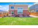 A home backyard featuring a well-maintained lawn, patio with furniture, and a brick exterior at 24285 E Wagon Trail Ave, Aurora, CO 80016
