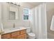 Clean bathroom with shower and tub combo, wood vanity, and bright lighting at 24285 E Wagon Trail Ave, Aurora, CO 80016