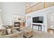 Bright living room features a fireplace, plush seating, and an open view into the modern kitchen at 24285 E Wagon Trail Ave, Aurora, CO 80016
