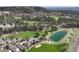 Aerial view of a neighborhood nestled alongside a lush golf course, ponds, and mature trees at 1361 Castlepoint Cir, Castle Pines, CO 80108