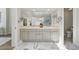 Elegant bathroom features a dual sink vanity, modern lighting, and marble floors at 1361 Castlepoint Cir, Castle Pines, CO 80108