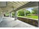 Covered outdoor patio with stone accents, ceiling fans, and a view of the landscaped backyard at 1361 Castlepoint Cir, Castle Pines, CO 80108