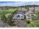 Beautiful home exterior with a large deck overlooking the lush green golf course at 1361 Castlepoint Cir, Castle Pines, CO 80108