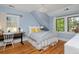 Charming bedroom with light blue walls, hardwood floors, and plenty of natural light from bright windows at 535 N High St, Denver, CO 80218