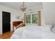 Well-lit bedroom features light-colored walls, a dark door, wood floors, and a decorative light fixture at 535 N High St, Denver, CO 80218