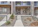 Close up of a townhome entrance with a modern door, concrete steps, and decorative landscaping at 9645 Browns Peak Cir, Littleton, CO 80125