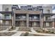 Modern townhomes featuring brick and siding exteriors, private balconies, and landscaped front yards at 9645 Browns Peak Cir, Littleton, CO 80125
