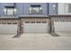 Townhome garages with brick facade and muted blue siding, creating a modern and appealing exterior at 9645 Browns Peak Cir, Littleton, CO 80125