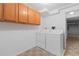 Laundry room with a white washer and dryer, storage cabinets, and a window for natural light at 1847 S Union Blvd, Lakewood, CO 80228