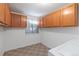 Bright laundry room with overhead cabinets and a window, providing ample space and natural light at 1847 S Union Blvd, Lakewood, CO 80228