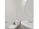 Modern half-bathroom features a vessel sink, round mirror, and a white toilet at 8809 Sedalia St, Commerce City, CO 80022