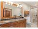 Bathroom with double sinks, granite countertop and a walk-in shower at 28940 Pinewood Vista Dr, Evergreen, CO 80439