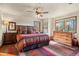 King-size bed, wooden dresser, and mountain views from the window at 28940 Pinewood Vista Dr, Evergreen, CO 80439