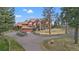 Luxury home with stone and wood exterior, expansive windows, and a large driveway at 28940 Pinewood Vista Dr, Evergreen, CO 80439