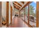 Long hallway with hardwood floors and access to a deck at 28940 Pinewood Vista Dr, Evergreen, CO 80439