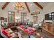 Spacious living room featuring a large antler chandelier and comfortable leather furniture at 28940 Pinewood Vista Dr, Evergreen, CO 80439