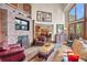 Rustic living room with a cozy stone fireplace and large windows at 28940 Pinewood Vista Dr, Evergreen, CO 80439